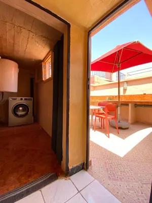 an open door to a patio with a table and an umbrella at Riyad Entier Avec piscine Red Moon Kech in Marrakech