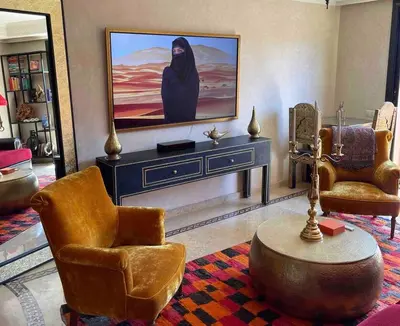 a living room with a tv and two chairs at Superbe appartement calme Hivernage in Marrakech