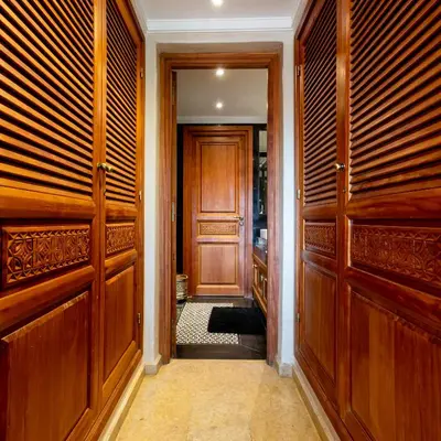 a hallway with wooden doors in a house at Superbe appartement calme Hivernage in Marrakech