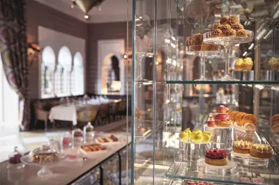 a display case in a bakery with cakes and pastries at Royal Mansour Marrakech in Marrakech
