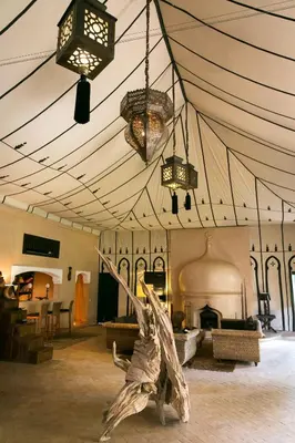 a room with a tent with a fireplace and lights at Lodge K in Marrakech