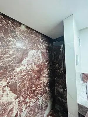 a bathroom with a brown marble wall at Résidence Mirador MAJORELLE in Marrakech