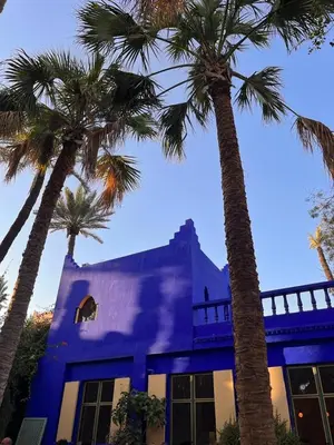 a blue building with palm trees in front of it at Résidence Mirador MAJORELLE in Marrakech