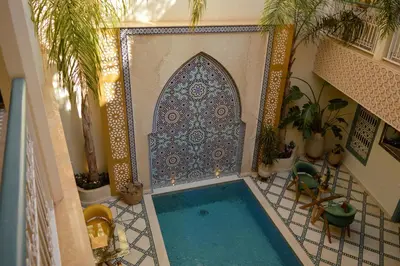 an indoor swimming pool in a house with a tile floor at Riad Jalina in Marrakech