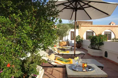 a patio with a table and an umbrella at Riad Clémentine in Marrakech