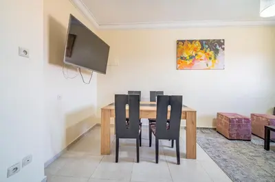 a dining room with a wooden table and chairs at Appartement 2 chambre 5min Aéroport in Marrakech