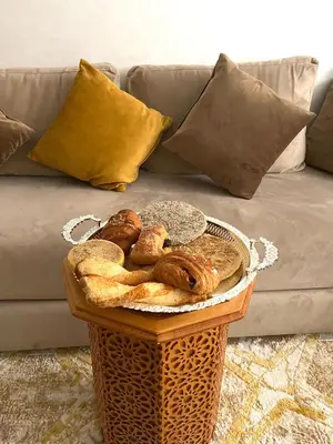 a basket of bread on a table in front of a couch at ASAMA appartement avec piscine et terrasse, proche du centre in Marrakech