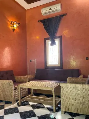 a room with a table and chairs and a window at Dxb Riad 4 suites in Marrakech