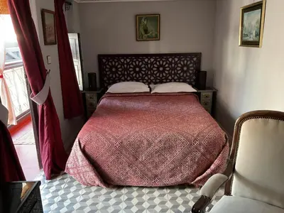 a bedroom with a bed with a red comforter at Riad Syba in Marrakech