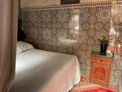 a bedroom with a bed and a wall at Riad Syba in Marrakech