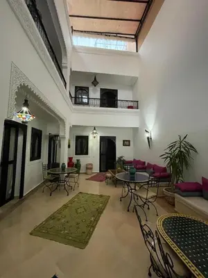 a living room with tables and chairs in a building at Dar Nossa in Marrakech