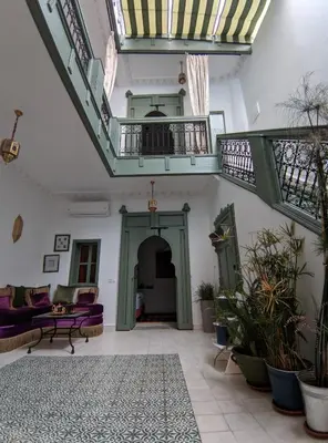 a large living room with stairs and tables and plants at RZ22, 5 min de Jemaa El Fna, 4 Pers, Fibre Optique Wi-Fi in Marrakech