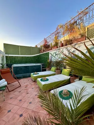 a patio with green furniture and stairs with plants at Riad Dar Adal exclusivité 2 à 6 personnes petit déjeuner compris place jemaa El fna in Marrakech