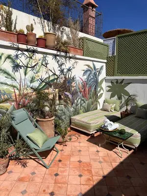a patio with chairs and a table and a wall with plants at Riad Dar Adal exclusivité 2 à 6 personnes petit déjeuner compris place jemaa El fna in Marrakech
