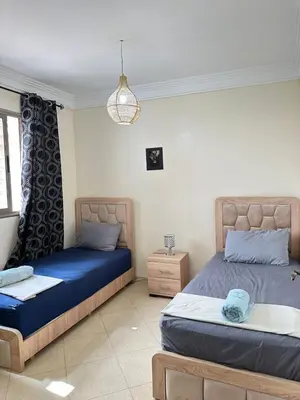 a bedroom with two beds and a chandelier at charming room close to Marrakech airport in Marrakech