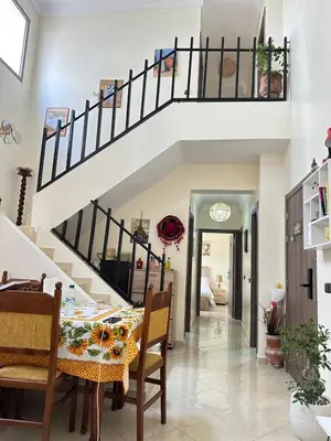 a dining room with a table and a staircase at charming room close to Marrakech airport in Marrakech