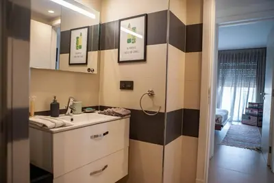 a bathroom with a sink and a mirror at Luxueux Appart Hivernage avec vue sur L''Atlas in Marrakech