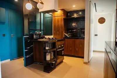 a kitchen with wooden cabinets and a stove top oven at Luxueux Appart Hivernage avec vue sur L''Atlas in Marrakech