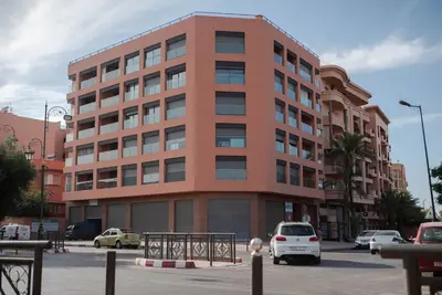 a large building with cars parked in front of it at Luxueux Appart Hivernage avec vue sur L''Atlas in Marrakech