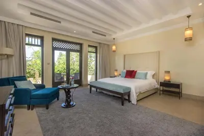 a bedroom with a bed and a couch and a chair at Luxury Villa GoldPalm Marrakech in Marrakech