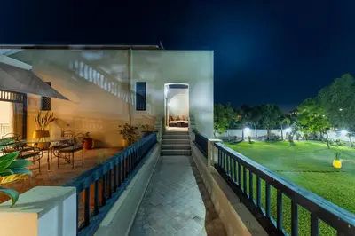 a balcony of a house with a lawn at night at Luxury Villa GoldPalm Marrakech in Marrakech
