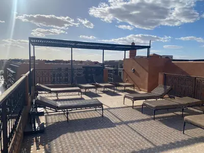 a group of benches sitting on top of a balcony at APP. Traversant au GUELIZ + Piscine sur le toit in Marrakech