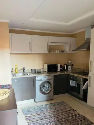 a kitchen with a washing machine and a microwave at Appartement centre Guéliz avec terrasse spacieuse in Marrakech
