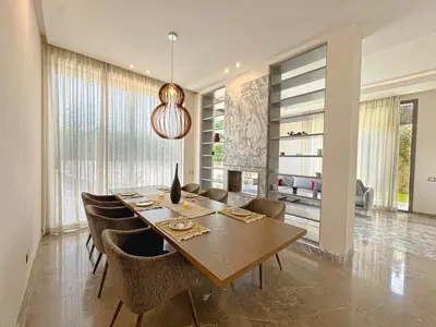 a dining room with a wooden table and chairs at Villa LEONARDO Piscine & Rooftop Terrase in Marrakech