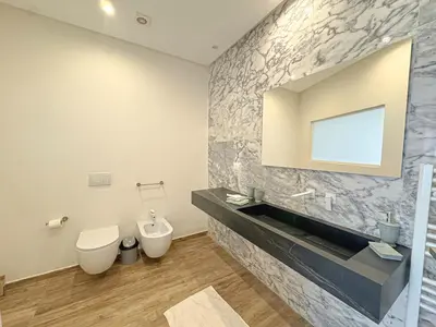 a bathroom with a sink and a toilet and a mirror at Villa LEONARDO Piscine & Rooftop Terrase in Marrakech
