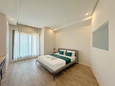 a bedroom with a bed and a large window at Villa LEONARDO Piscine & Rooftop Terrase in Marrakech