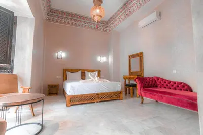 a bedroom with a bed and a red couch at Riad Deluxe in Marrakech