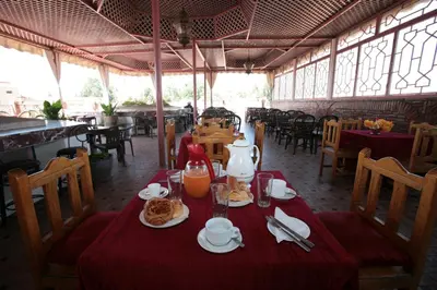 a dining room with a table with food on it at Hotel Ichbilia فندق اشبيلية in Marrakech