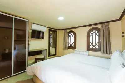 a bedroom with a large white bed and two windows at Luxury Villa 6 ROOMS with Pool - Marrakech Center in Marrakech
