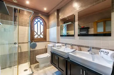 a bathroom with two sinks and a toilet and a shower at Luxury Villa 6 ROOMS with Pool - Marrakech Center in Marrakech
