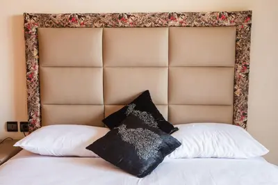a bed with a padded headboard with two pillows on it at A stunning 2 bedroom Hivernage in Marrakech