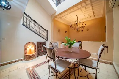 a dining room with a table and chairs and a chandelier at Riad Résidence Al Qaria Assiyahia Riad 22 in Marrakech
