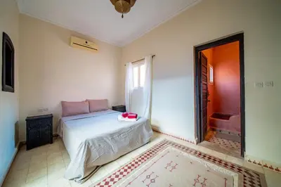 a bedroom with a bed and a window and a tub at Riad Résidence Al Qaria Assiyahia Riad 22 in Marrakech