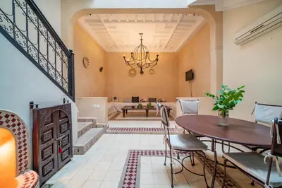 a dining room with a table and a chandelier at Riad Résidence Al Qaria Assiyahia Riad 22 in Marrakech