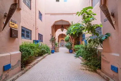 an alley way in an old building with plants at Riad Résidence Al Qaria Assiyahia Riad 22 in Marrakech