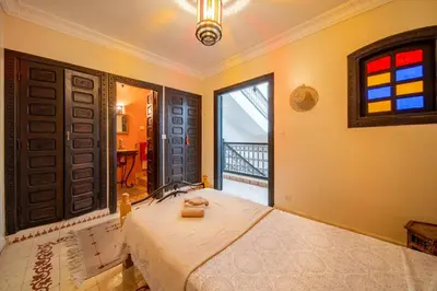 a bedroom with a large bed and a window at Riad Résidence Al Qaria Assiyahia Riad 22 in Marrakech