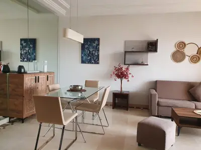 a living room with a table and a couch at Vizir Center Appartements in Dar Caïd Layadi