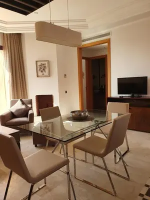 a living room with a glass table and chairs at Vizir Center Appartements in Dar Caïd Layadi
