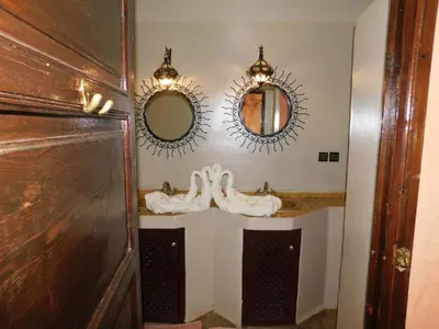 a bathroom with two mirrors and a sink at Riad BAHIA in Marrakech