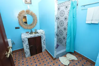a blue bathroom with a sink and a mirror at Riad BAHIA in Marrakech