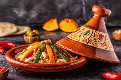 an orange bowl of food with vegetables in it at Riad BAHIA in Marrakech