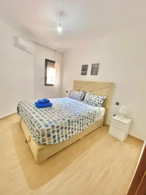 a bedroom with a bed with a blue towel on it at Appartement avec piscine en face à la gare gueliz in Marrakech