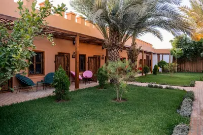 a house with a palm tree in the yard at Le Palais Averroes - Adults Only in Marrakech