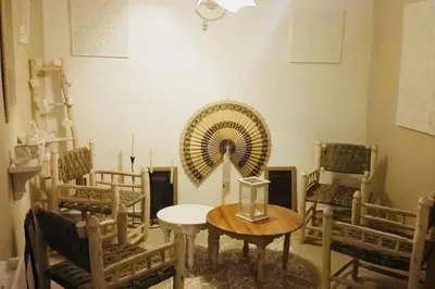 a room with a table and chairs and a fan at Maison Alegria , Heart of Medina in Marrakech