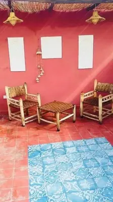 a room with two chairs and a red wall at Maison Alegria , Heart of Medina in Marrakech