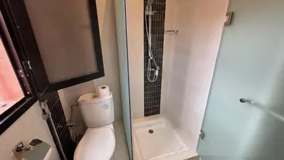 a small bathroom with a toilet and a shower at Magnifique appartement Marrakech in Marrakech